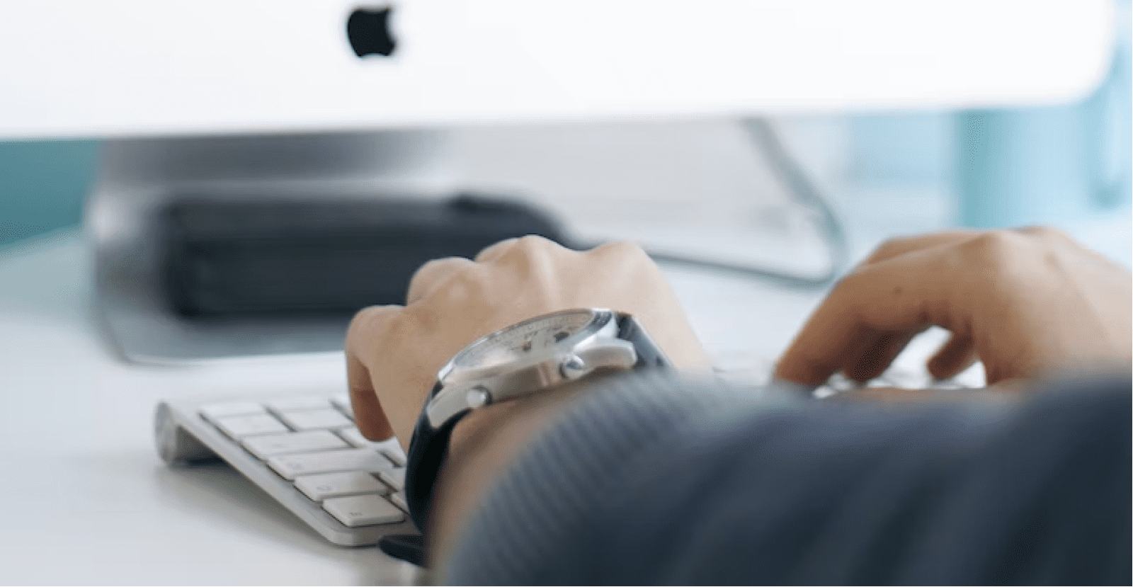 Hands typing on a computer monitor