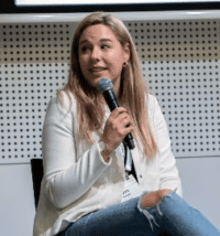 Be seen, be heard A person sitting in a chair at a cybersecurity conference holding a microphone