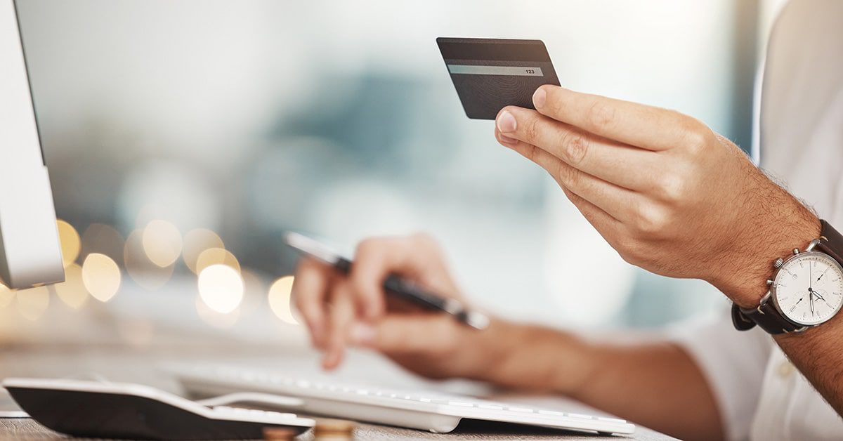 A person typing in their credit card details in to an online bank