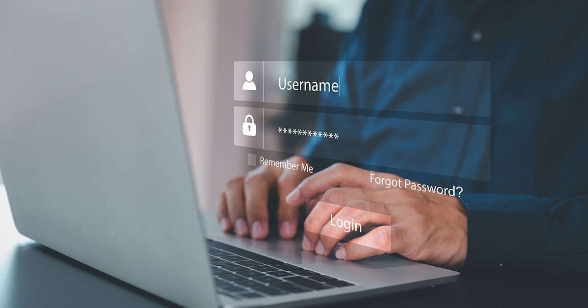 Attacker typing username and password into computer to break into an account