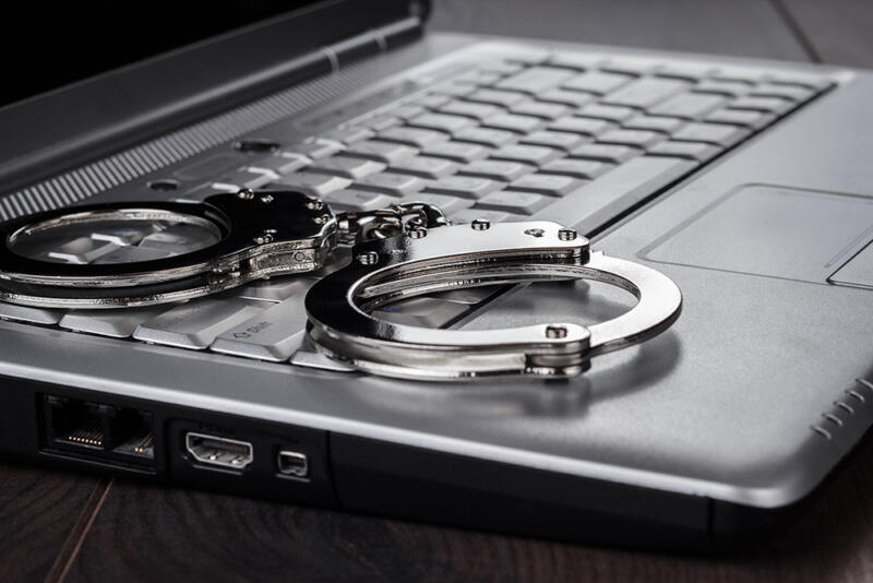metal handcuffs on laptop keyboard 