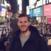 A man standing in front of a crowd in times square.