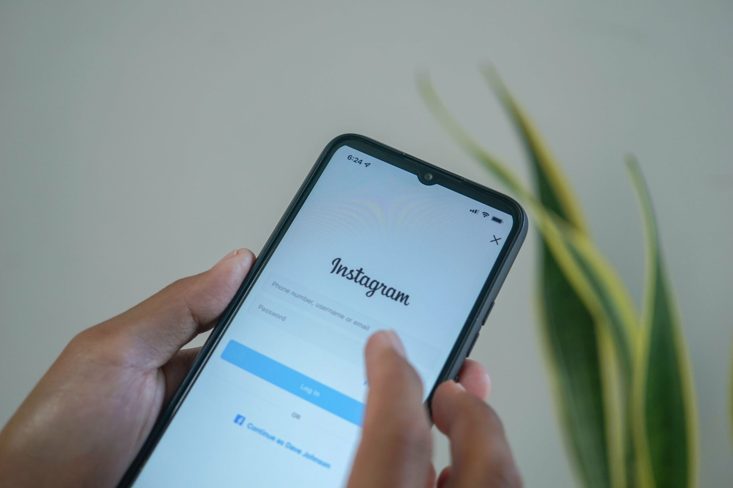 person holding phone of instagram login screen 