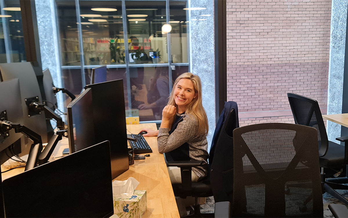A Kasada employee in the office at her desk smiling