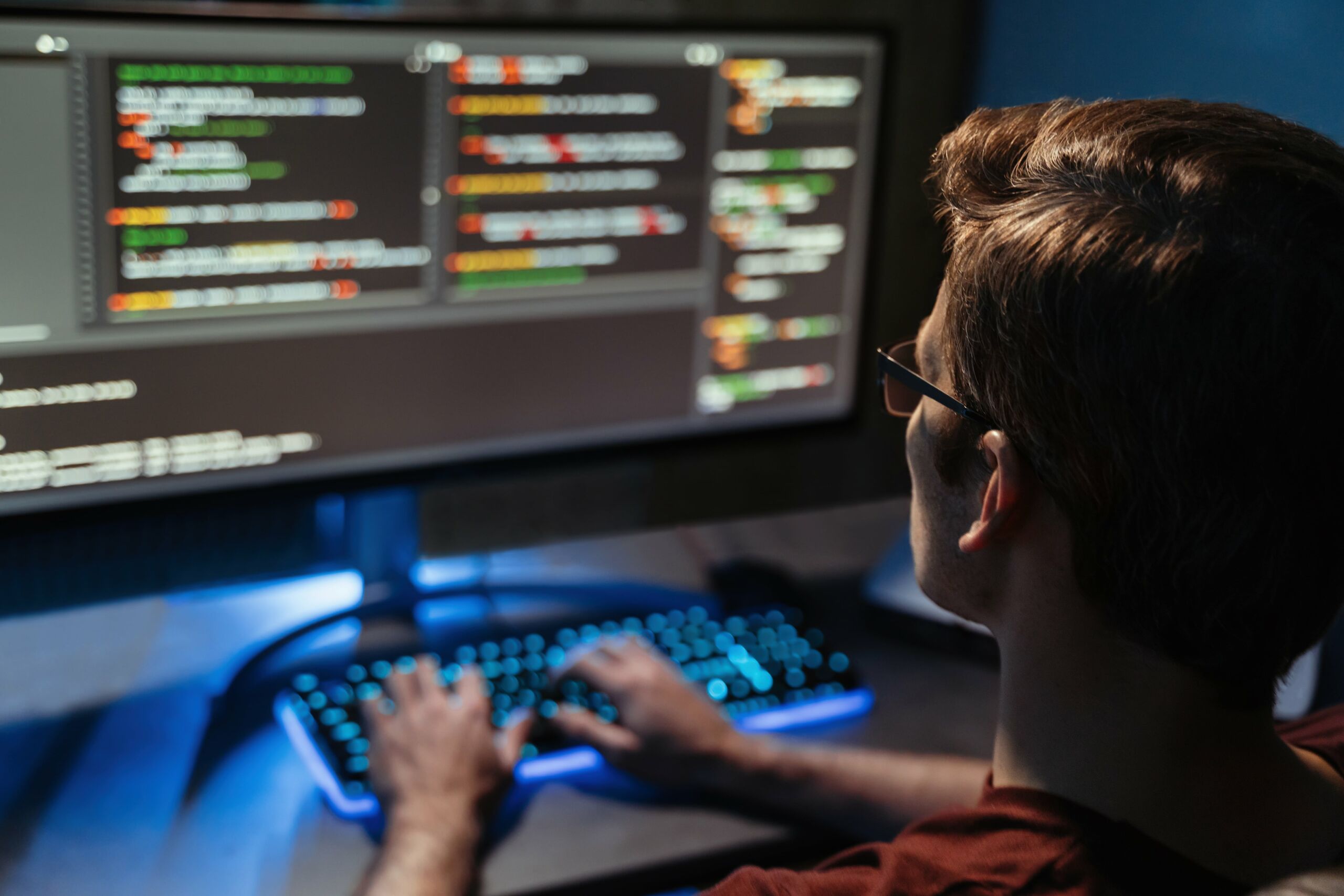 back view of a man coding for cyber security program 