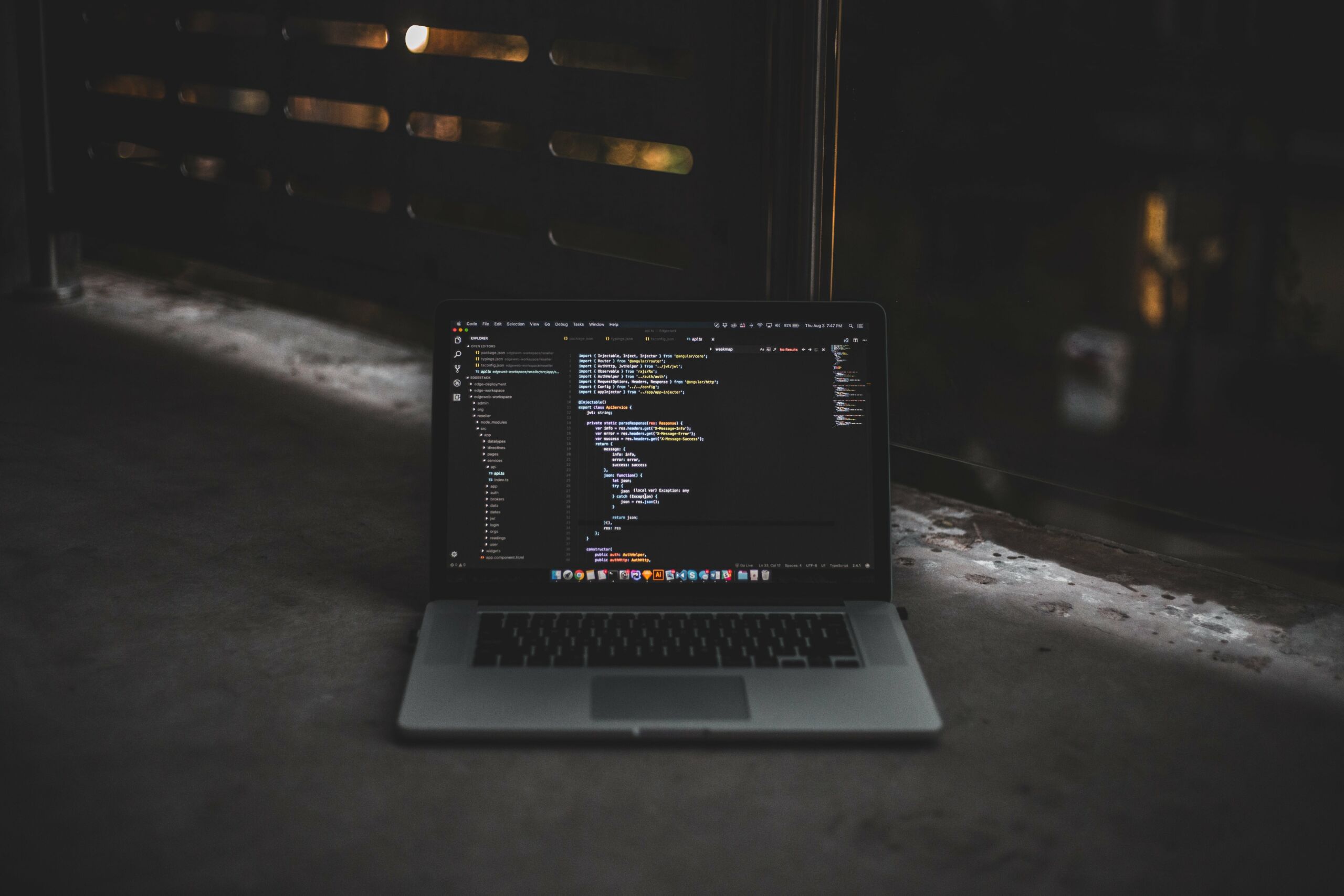 laptop screen with code across it in dark room 