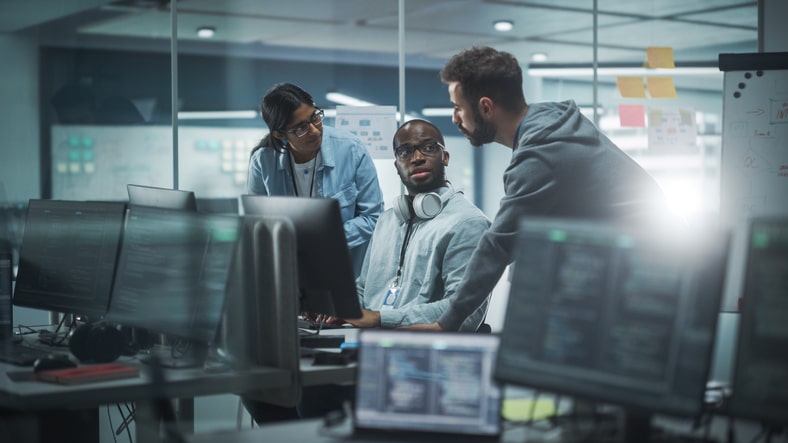 people standing behind computer meeting