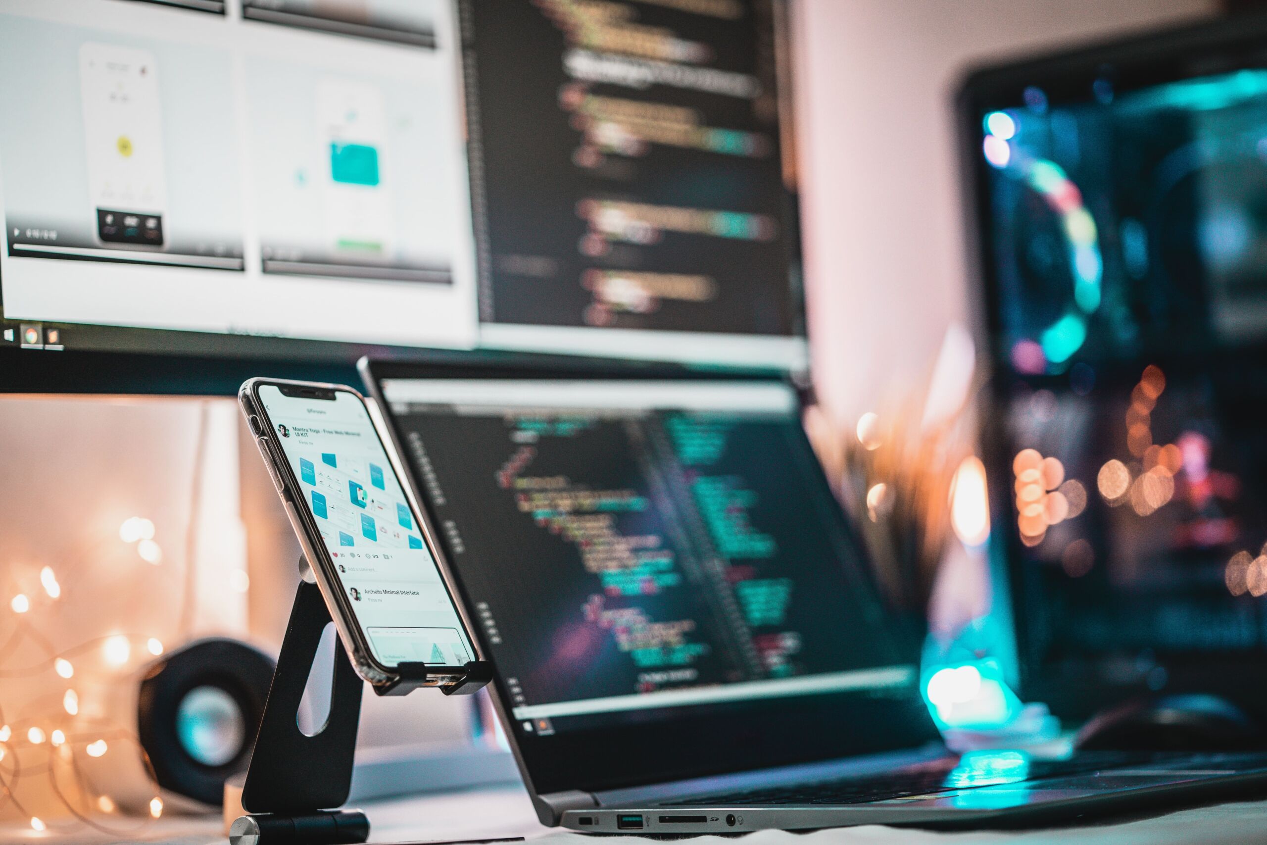 laptop and computer screens with code