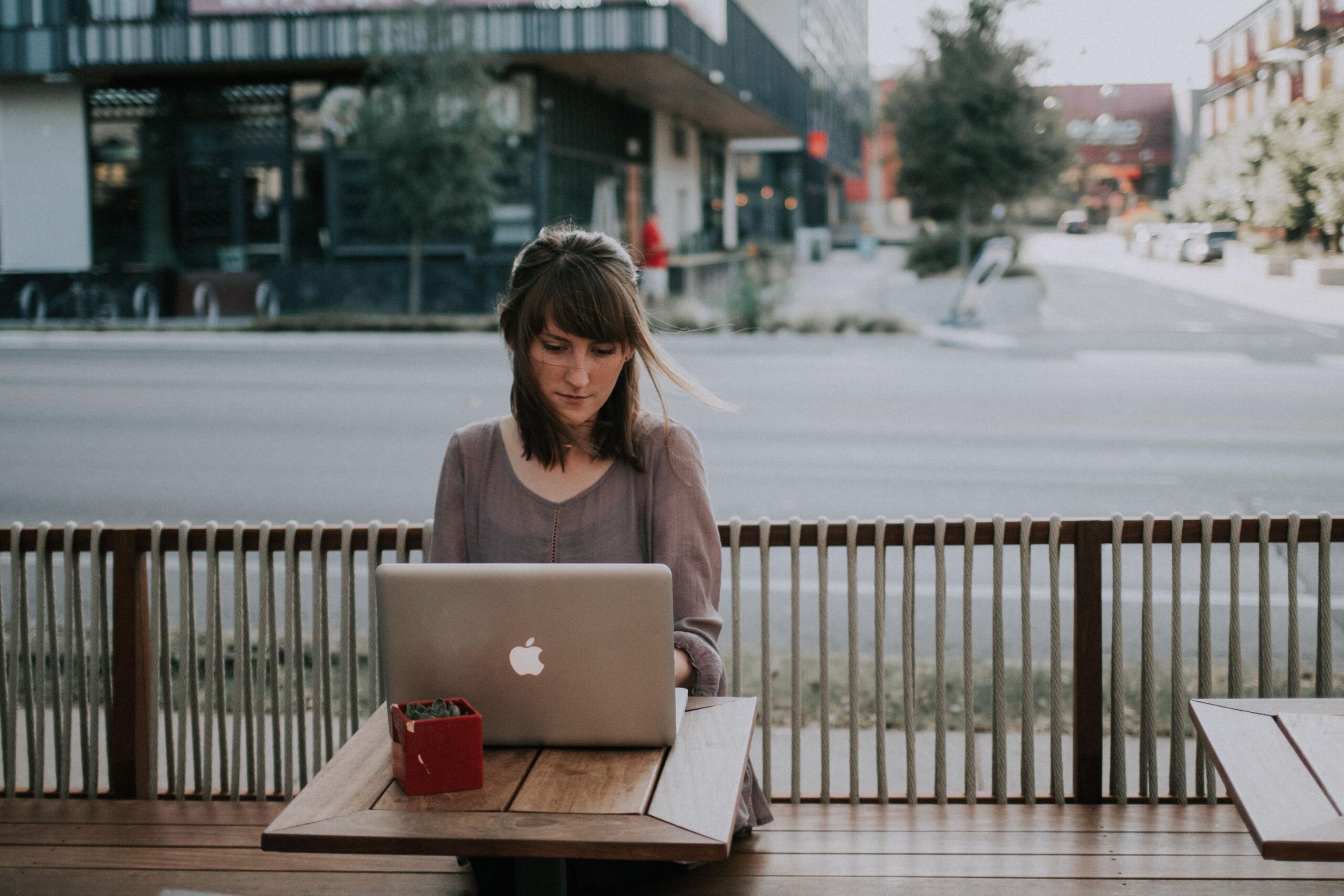person at outdoor seating on laptop