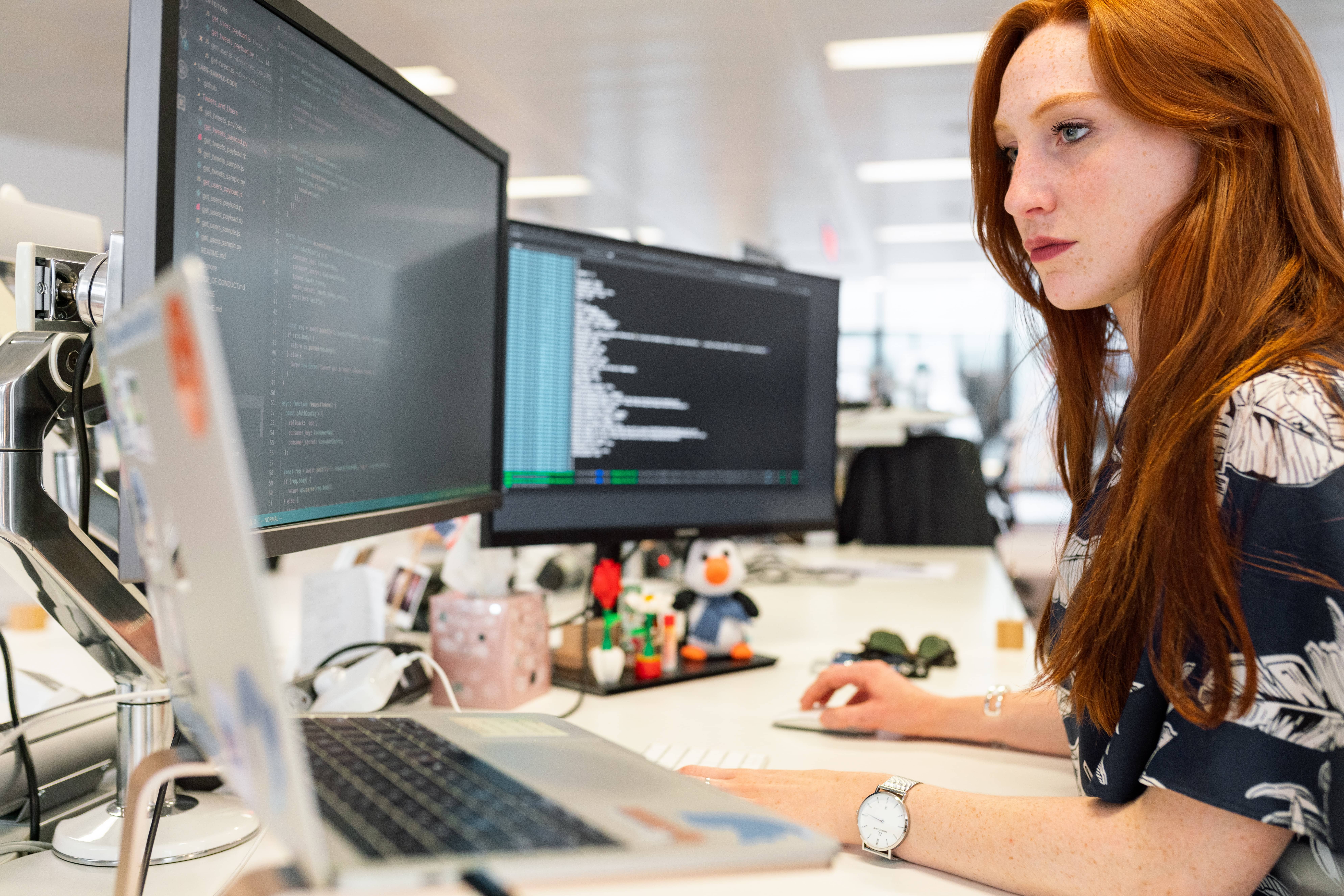 woman working on triple screens at work