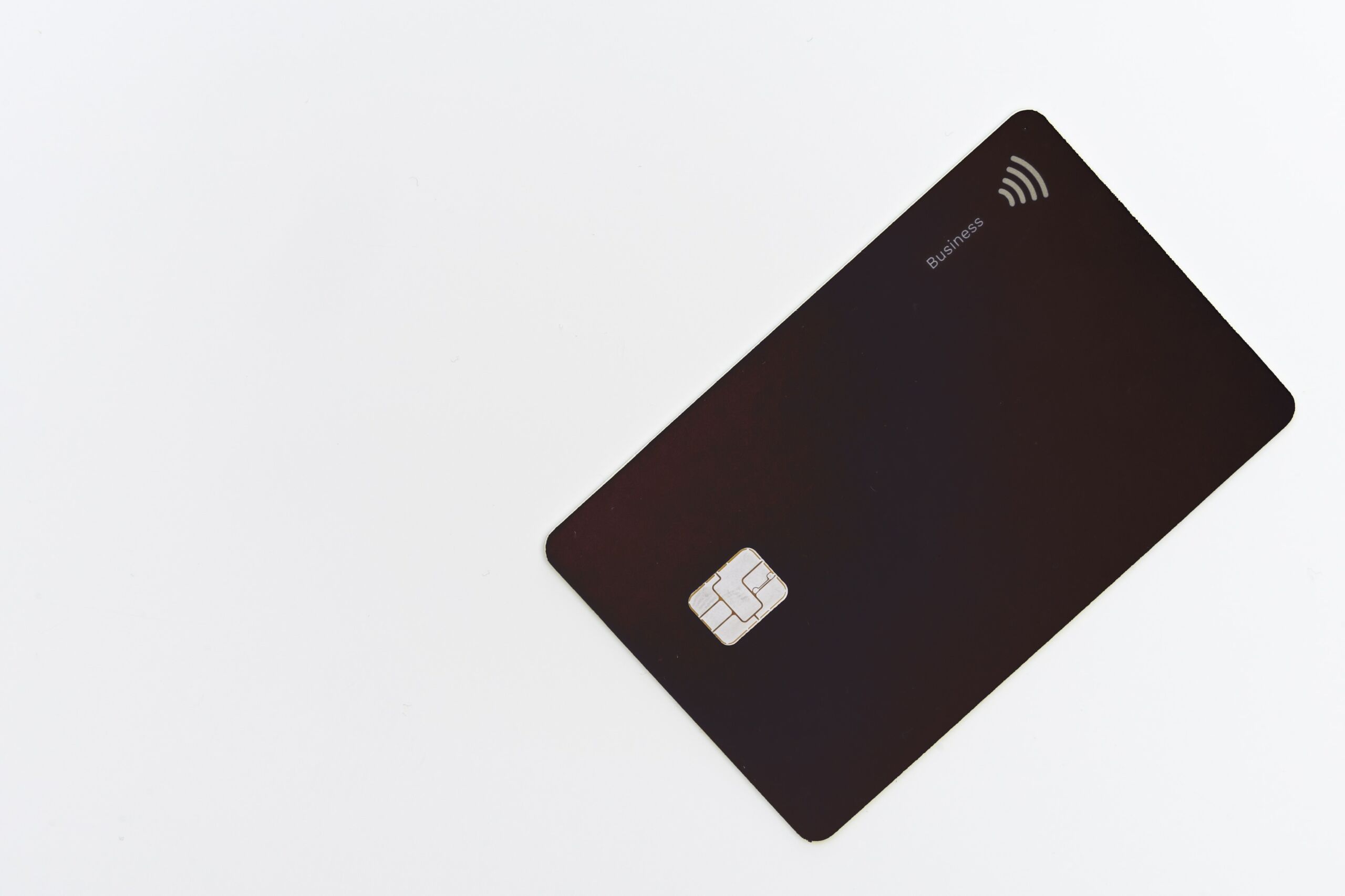 A black credit card resting on a pristine white surface.