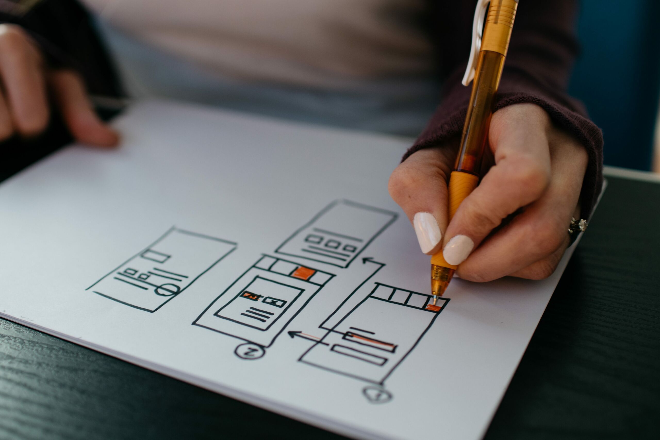 A person skillfully sketching a diagram on a piece of paper.
