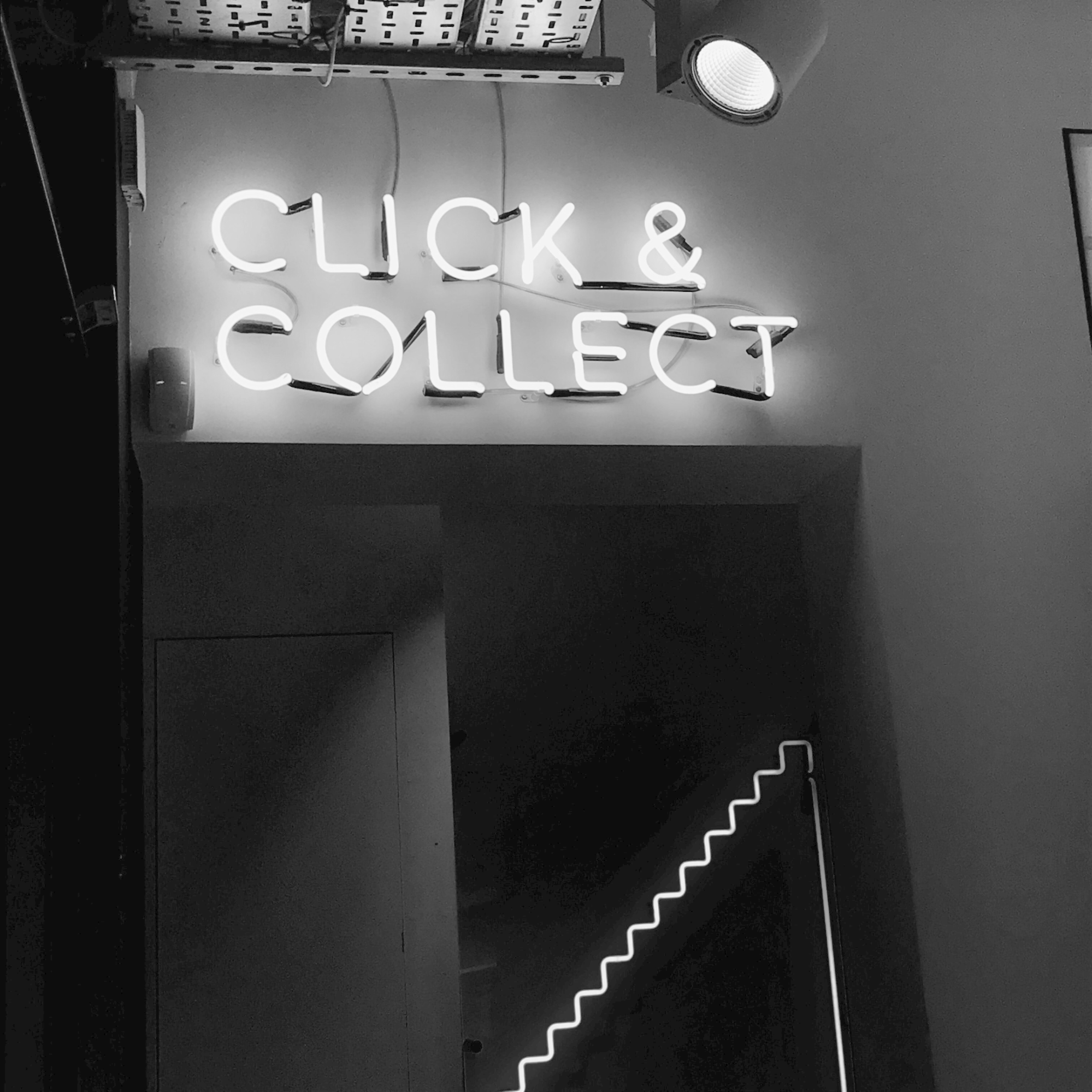 A black and white photo of a sign that says click and collect.
