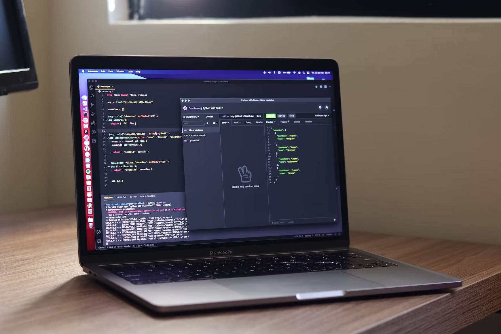 A laptop is sitting on a desk next to a monitor.