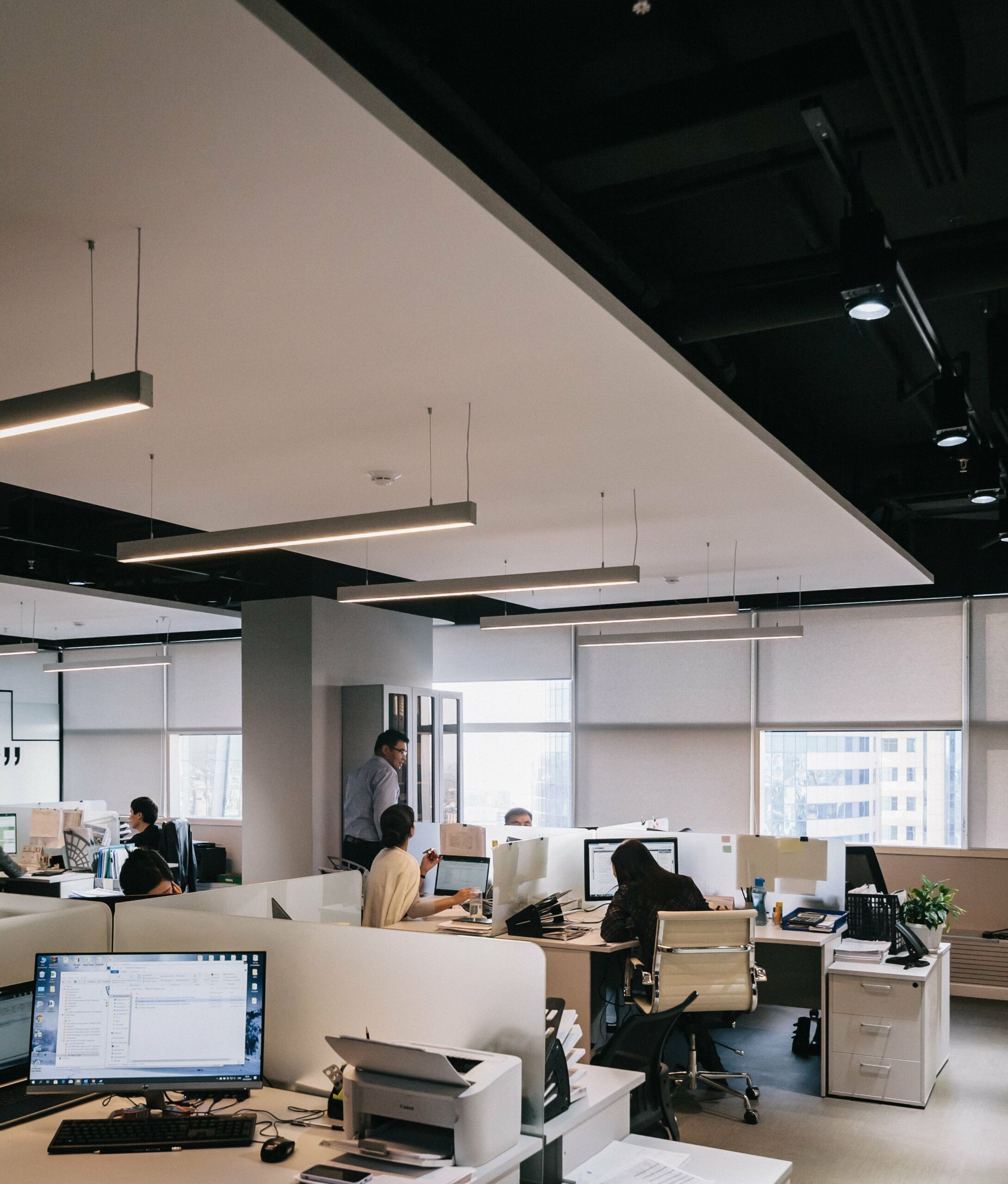 An empty office with people working at desks.
