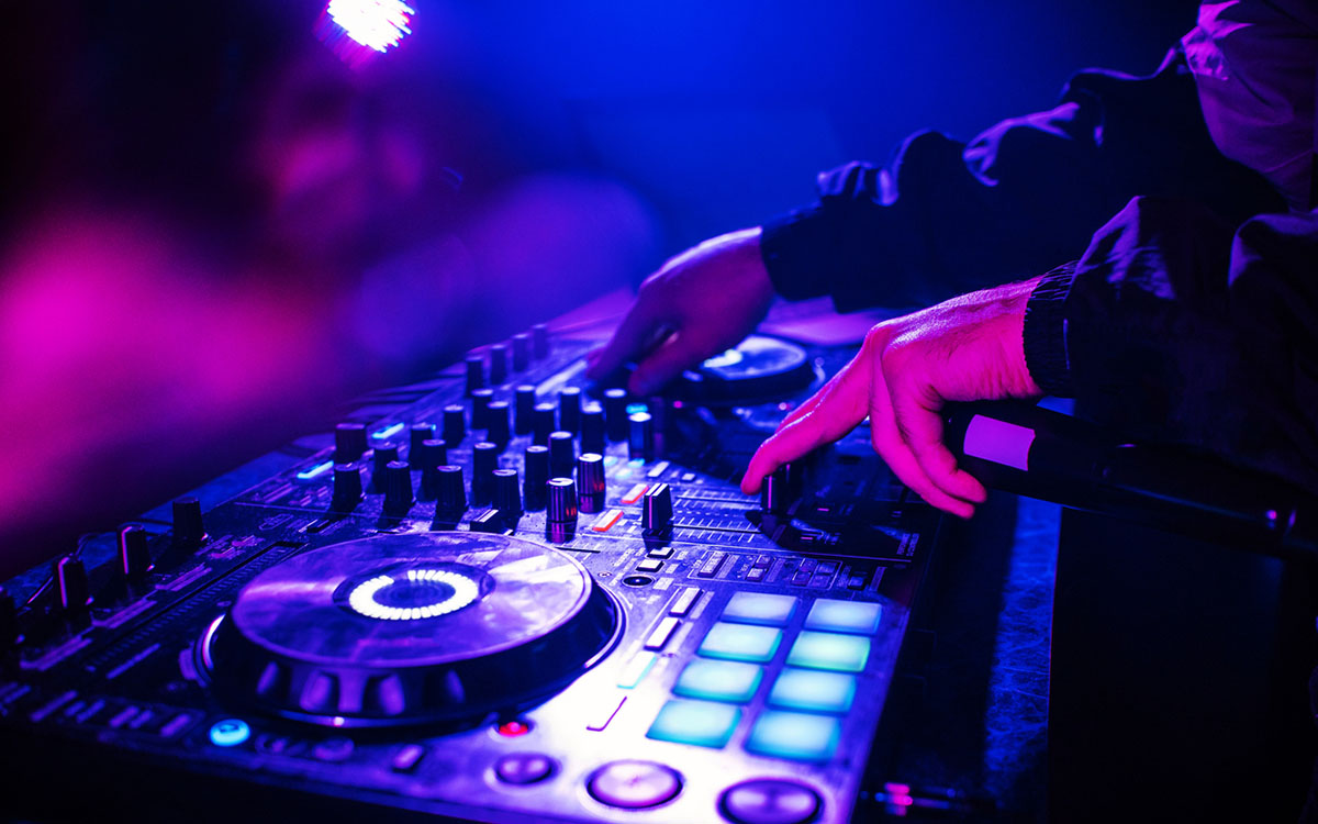 Dj mixing tracks on a club dj console with vibrant lighting, avoiding scalpers outside.